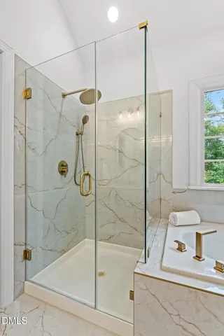 a bathroom with a tub a sink and a large window