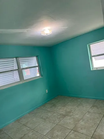 a view of an empty room with windows & washer