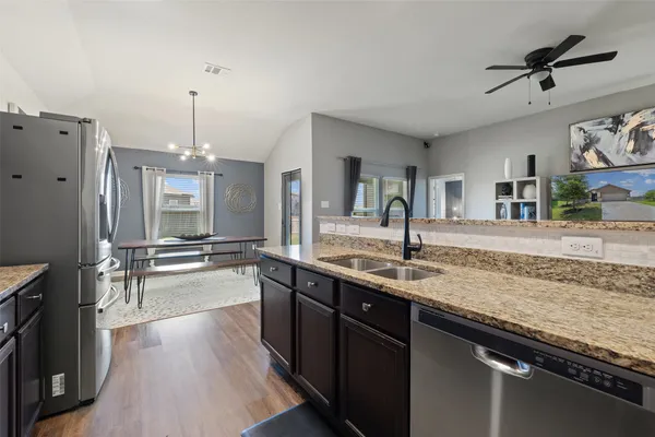 a kitchen with stainless steel appliances granite countertop a sink stove and refrigerator