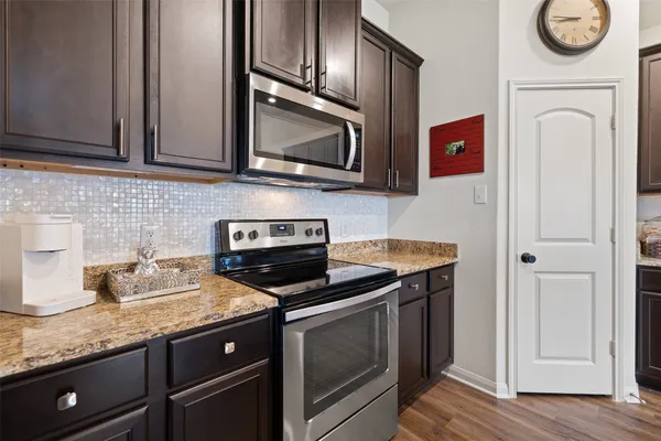 a kitchen with granite countertop stainless steel appliances a stove microwave and sink