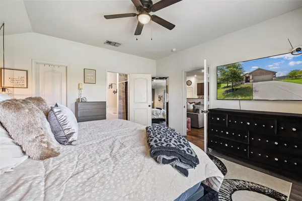 a bedroom with a bed dresser and wooden floor
