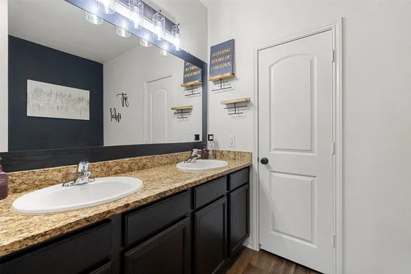 a bathroom with a granite countertop sink and a mirror
