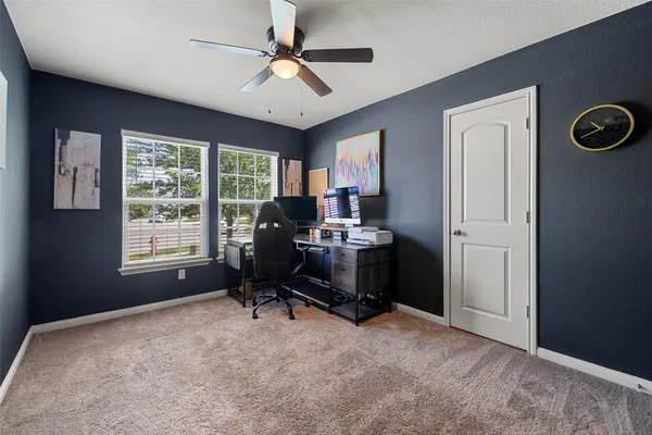 a view of a workspace with furniture and a window
