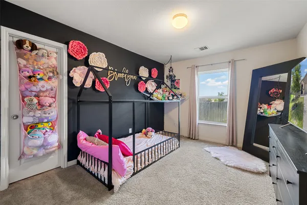 a bedroom with lots of white and a pink couch