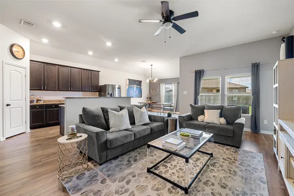 a living room with furniture and a wooden floor