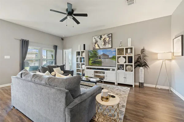 a living room with furniture and wooden floor