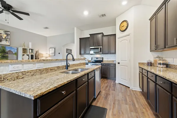 a kitchen with sink cabinets and wooden floor