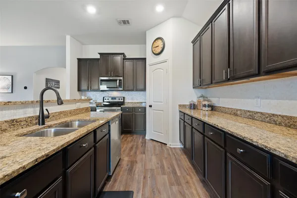 a kitchen with stainless steel appliances granite countertop a sink stove and refrigerator