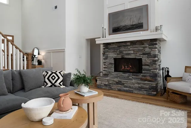 a living room with furniture a flat screen tv and a fireplace