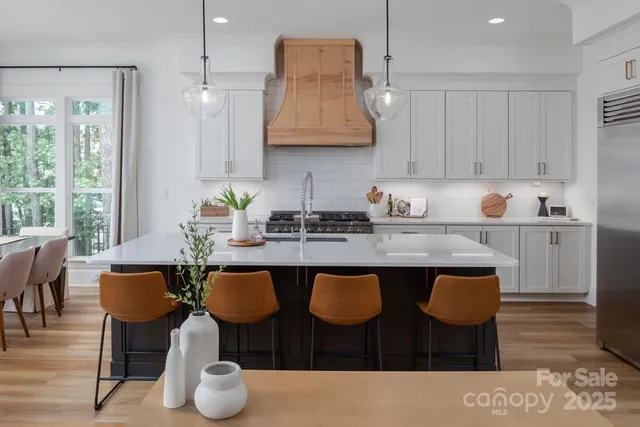 a kitchen with granite countertop a dining table chairs and white cabinets