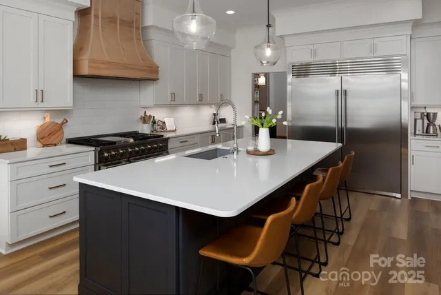 a kitchen with stainless steel appliances a table chairs and a refrigerator