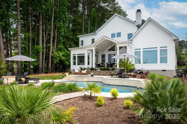 a view of a house with swimming pool and sitting area