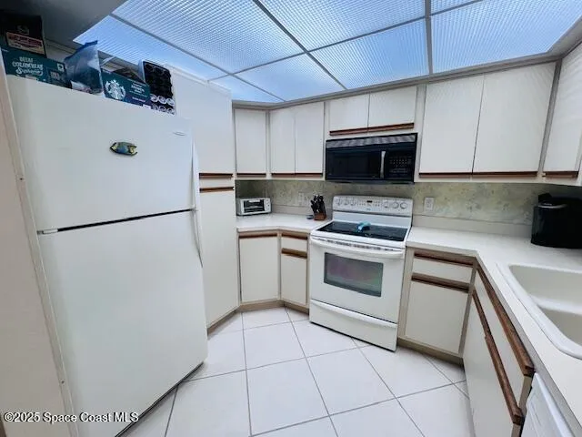 a kitchen with a refrigerator sink and cabinets
