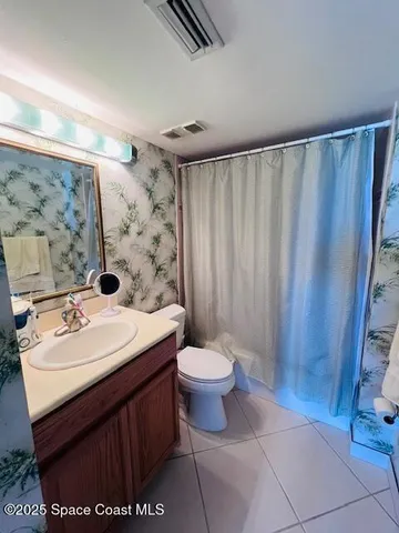 a bathroom with a sink a toilet and shower curtain