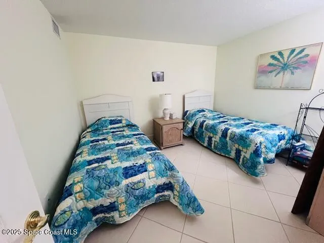 a bedroom with two bed and a painting on the wall