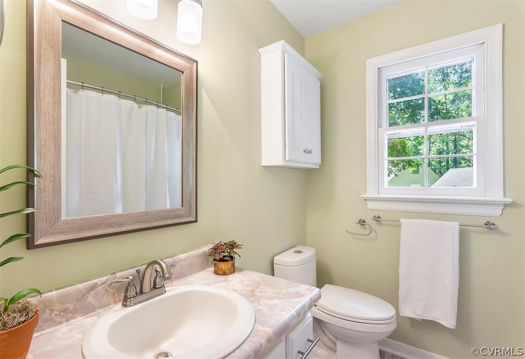 13815 Sterlings Bridge Road Midlothian, VA 23112 - Photo 21 of 27 a bathroom with a toilet a sink a mirror and a window