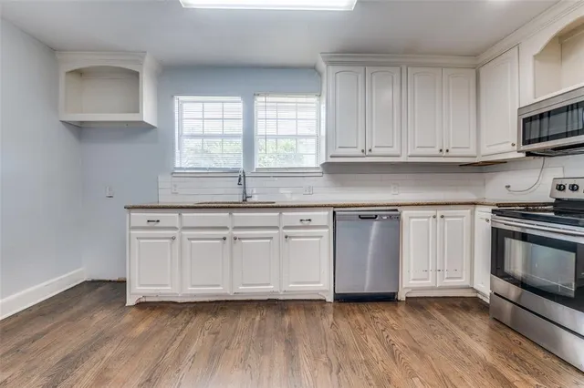 a kitchen with granite countertop white cabinets and white appliances