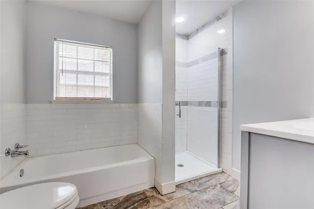 a bathroom with a tub shower and toilet