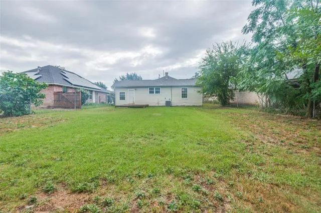 a view of a house with a big yard and large trees
