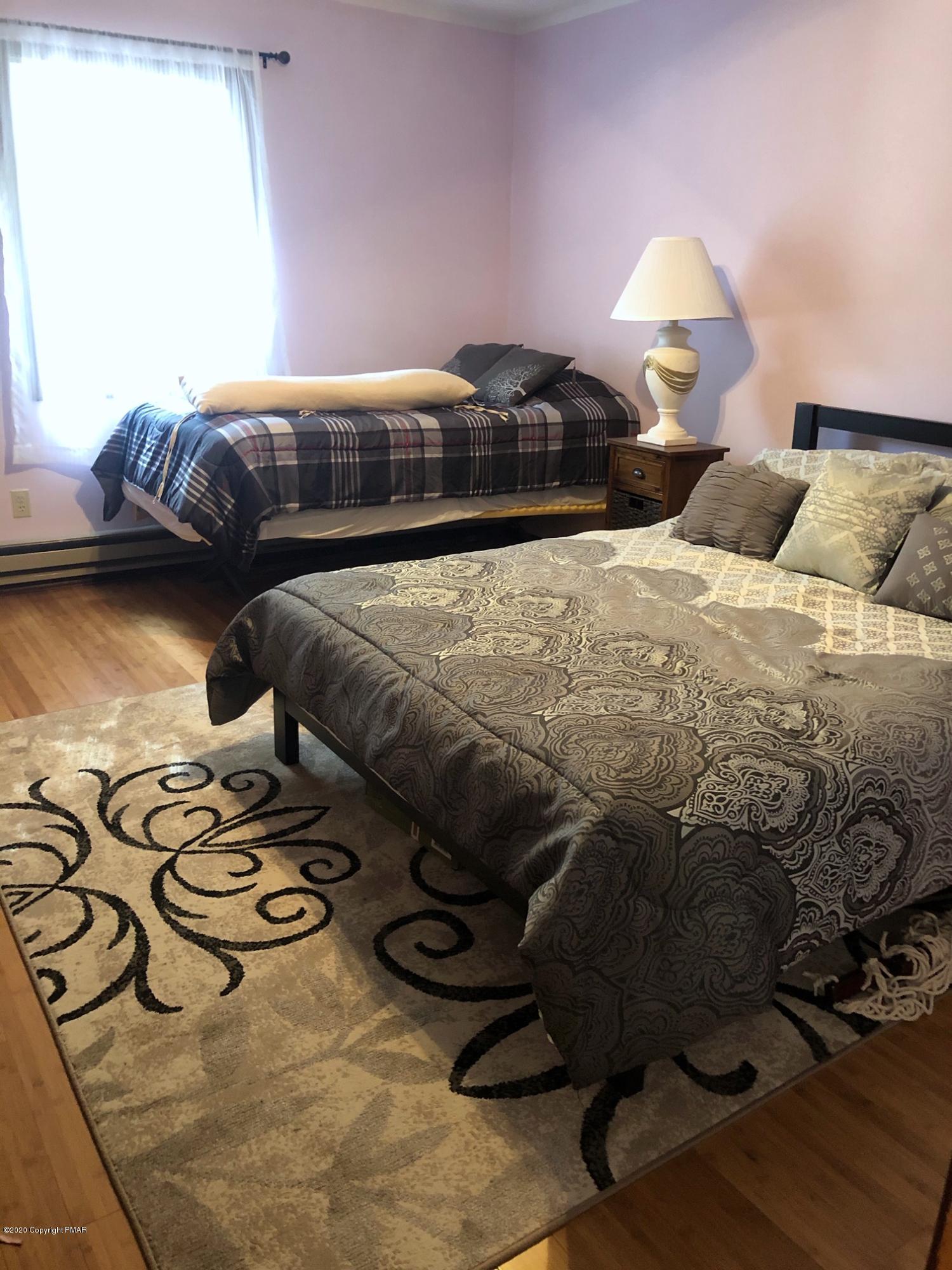 223 Sage Road Long Pond, PA 18334 - Photo 15 of 28 a bedroom with a bed and a chandelier