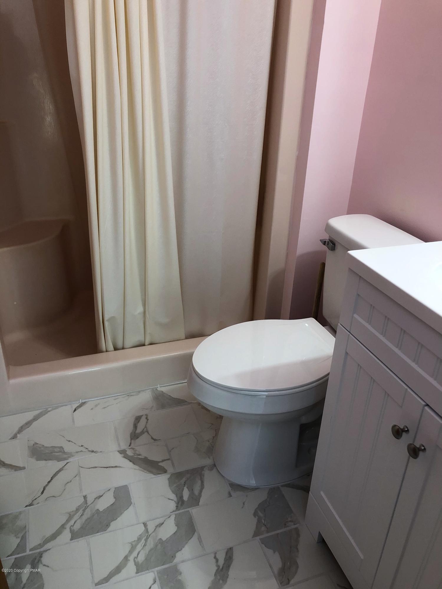 223 Sage Road Long Pond, PA 18334 - Photo 22 of 28 a white toilet sitting next to a shower curtain