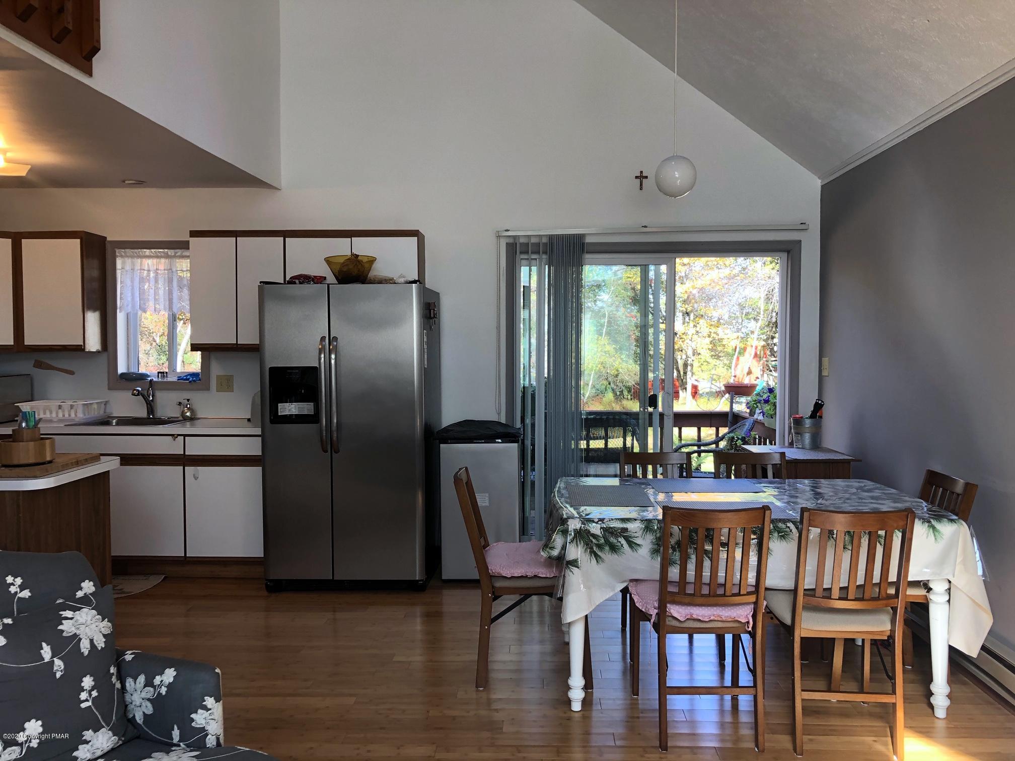 223 Sage Road Long Pond, PA 18334 - Photo 10 of 28 a kitchen with granite countertop a refrigerator a stove a dining table and chairs