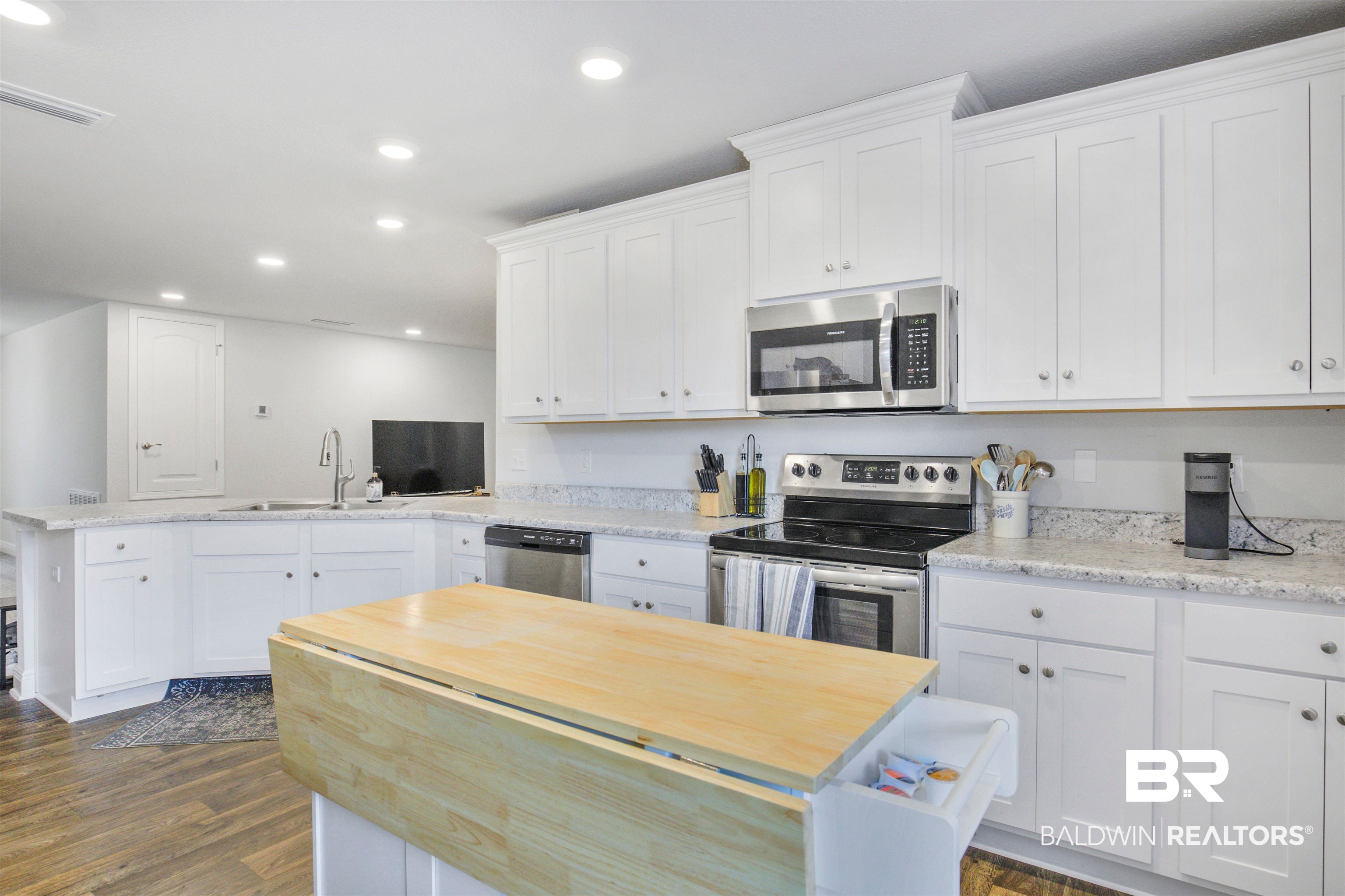 1970 Redpine Drive Semmes, AL 36575 - Photo 3 of 25 Kitchen with a peninsula, white cabinetry, stainless steel appliances, and a sink