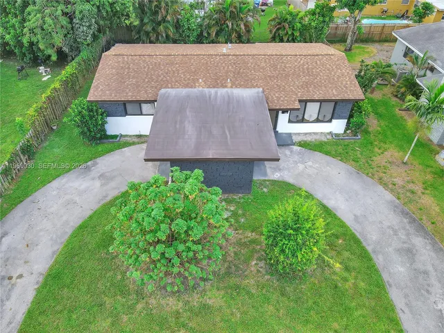 a aerial view of a house with a yard and trees