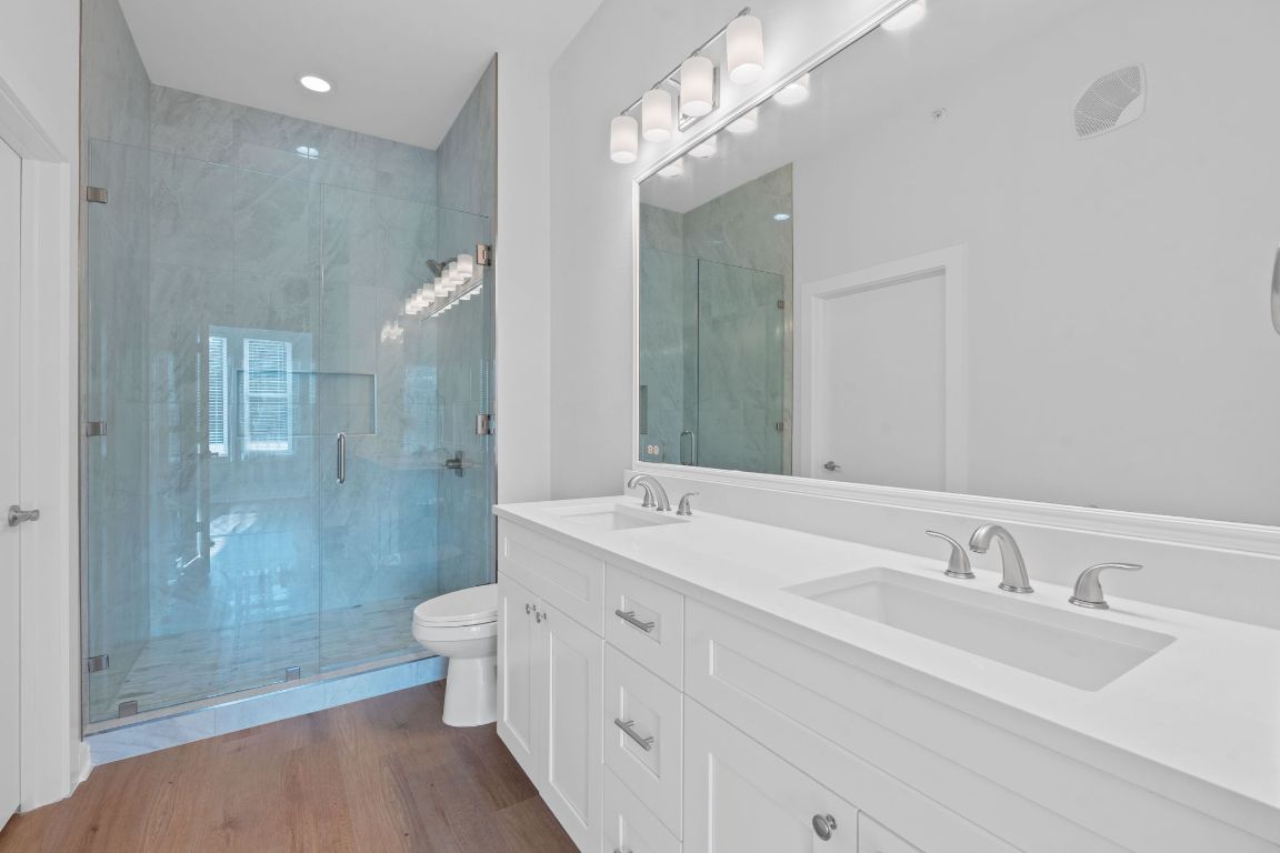 1900 Barton Springs Road, Unit 2019 Austin, TX 78704 - Photo 12 of 30 a bathroom with a double vanity sink mirror double shower and a toilet