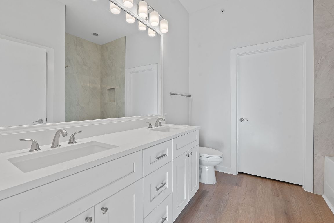 1900 Barton Springs Road, Unit 2019 Austin, TX 78704 - Photo 16 of 30 a bathroom with a double vanity sink a toilet and a mirror