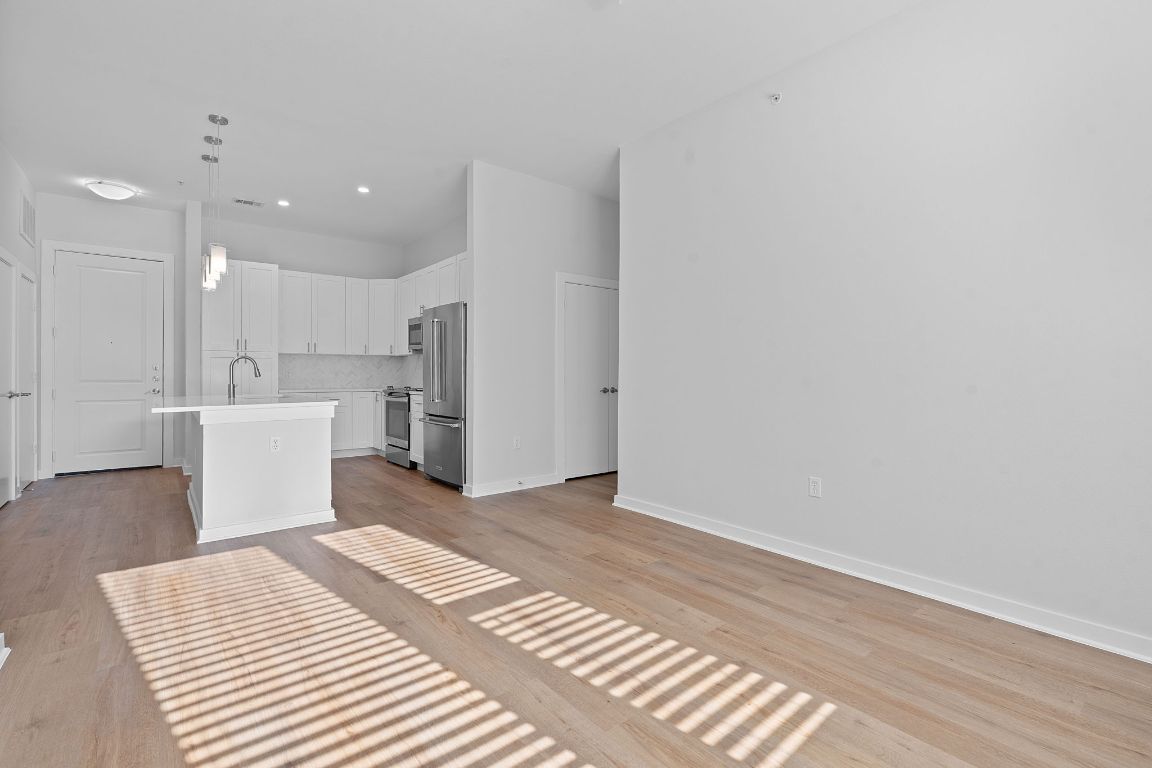 1900 Barton Springs Road, Unit 2019 Austin, TX 78704 - Photo 2 of 30 a view of a kitchen with white cabinets and wooden floor