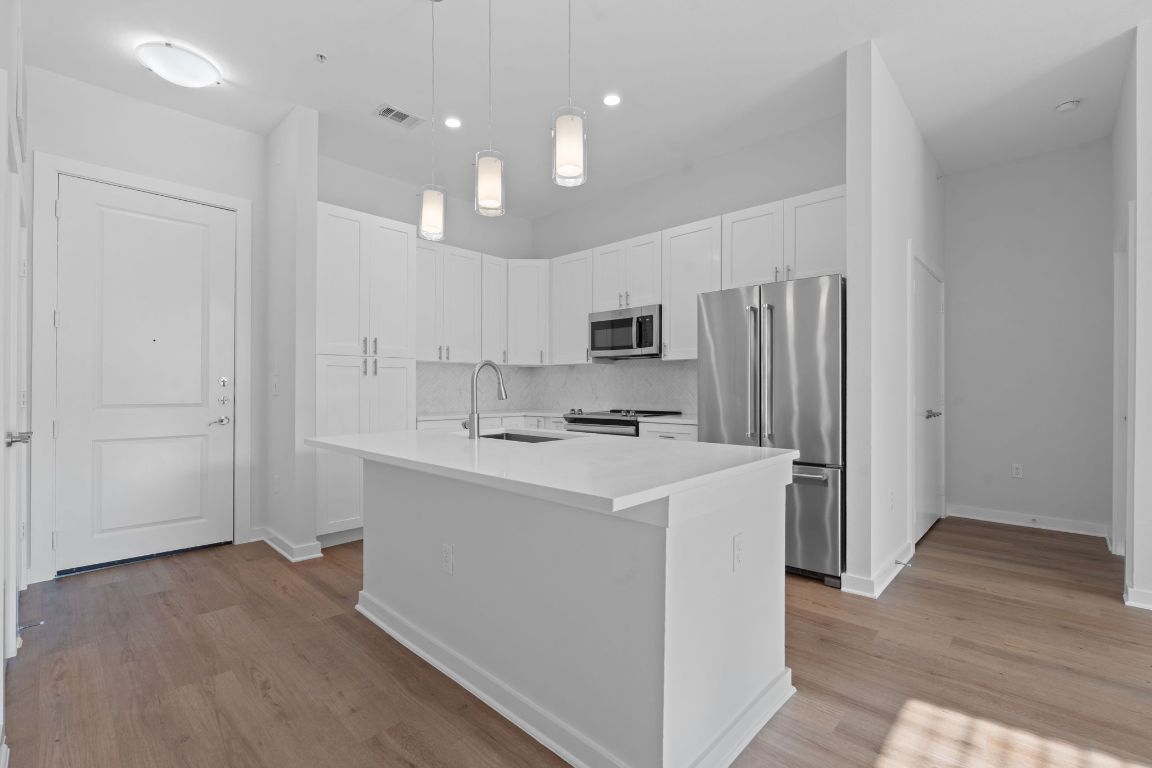 1900 Barton Springs Road, Unit 2019 Austin, TX 78704 - Photo 5 of 30 a kitchen with kitchen island a sink stainless steel appliances and cabinets