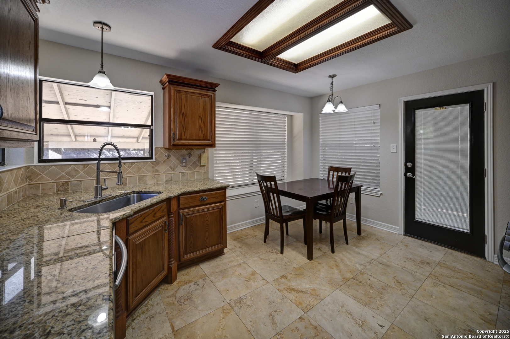 7543 Beaver Tree San Antonio, TX 78249 - Photo 11 of 38 a kitchen with granite countertop dining table chairs cabinets and stainless steel appliances