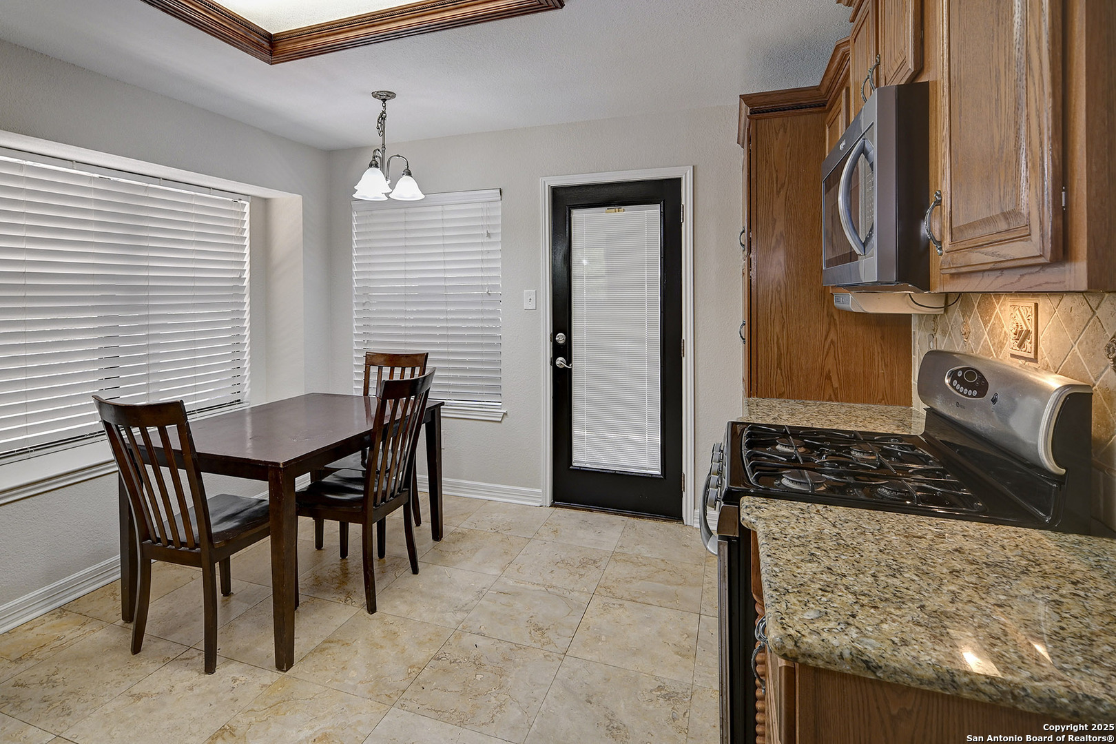 7543 Beaver Tree San Antonio, TX 78249 - Photo 10 of 38 a kitchen with stainless steel appliances granite countertop a stove top oven a sink a dining table and chairs
