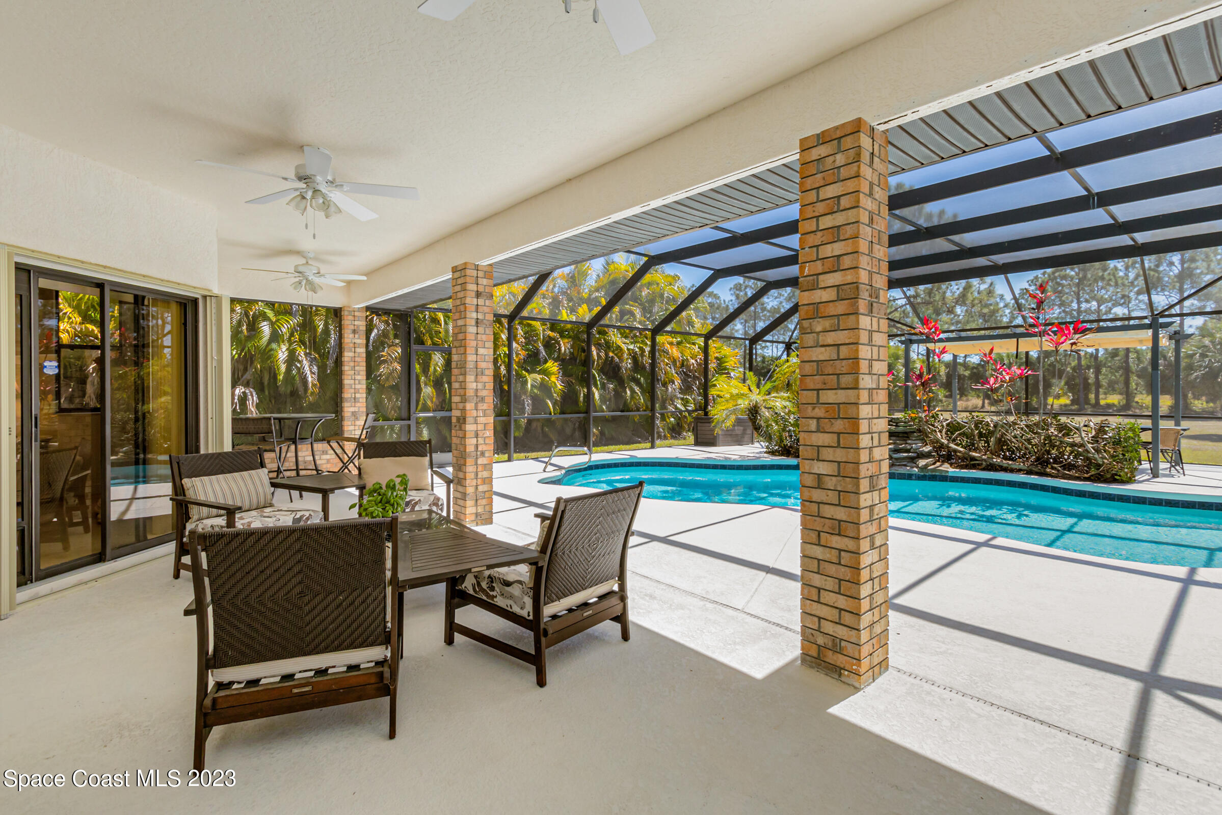 271 Deer Run Road Palm Bay, FL 32909 - Photo 48 of 61 a living room with patio furniture and a floor to ceiling window