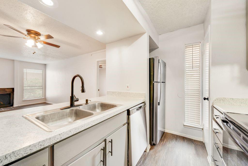 5514 Boca Raton Boulevard, Unit 438 Fort Worth, TX 76112 - Photo 8 of 25 a kitchen with stainless steel appliances granite countertop a sink and a refrigerator
