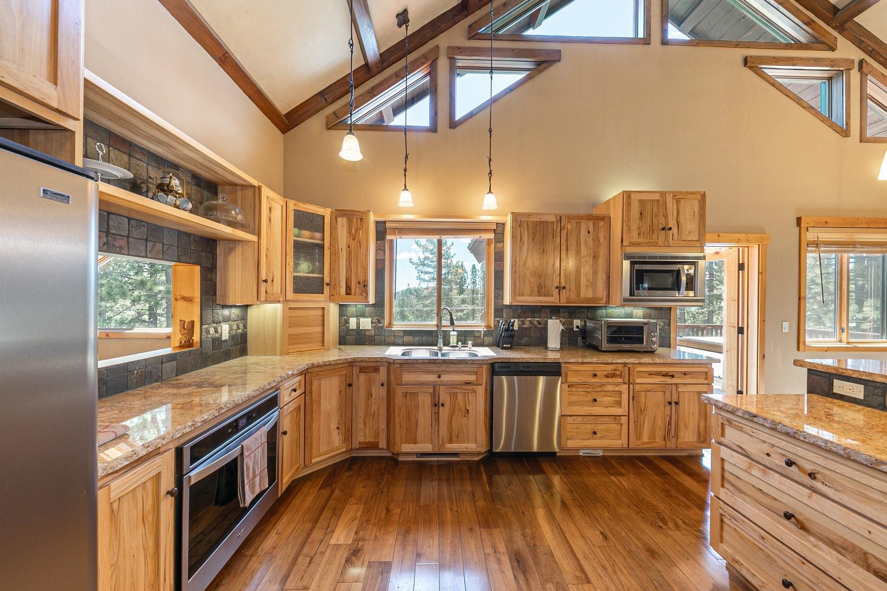 14070 Alder Creek Road Truckee, CA 96161 - Photo 6 of 28 a large kitchen with granite countertop a stove top oven a sink a dining table and chairs