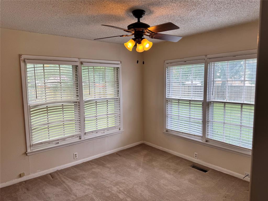 1824 North Binkley Street Sherman, TX 75092 - Photo 11 of 19 Carpeted empty room featuring plenty of natural light, a ceiling fan, and a textured ceiling