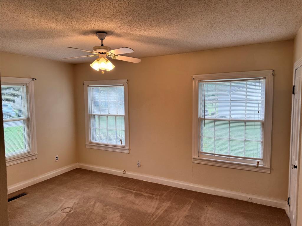 1824 North Binkley Street Sherman, TX 75092 - Photo 12 of 19 Empty room featuring a textured ceiling, carpet, and ceiling fan