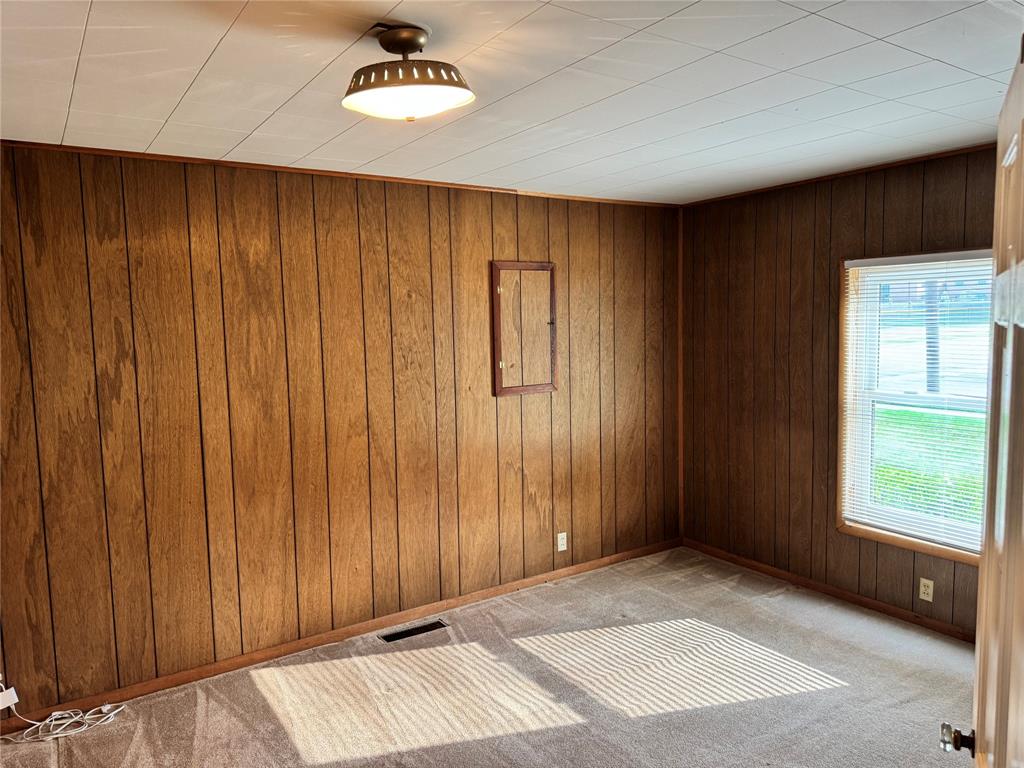 1824 North Binkley Street Sherman, TX 75092 - Photo 10 of 19 Spare room with wood walls and light carpet