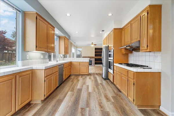 a kitchen with stainless steel appliances sink refrigerator and cabinets