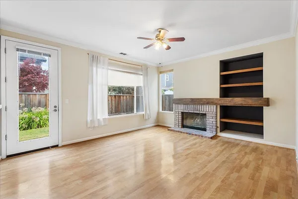 a view of an empty room with a fireplace and a window