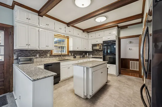 a kitchen with granite countertop a sink stove and refrigerator