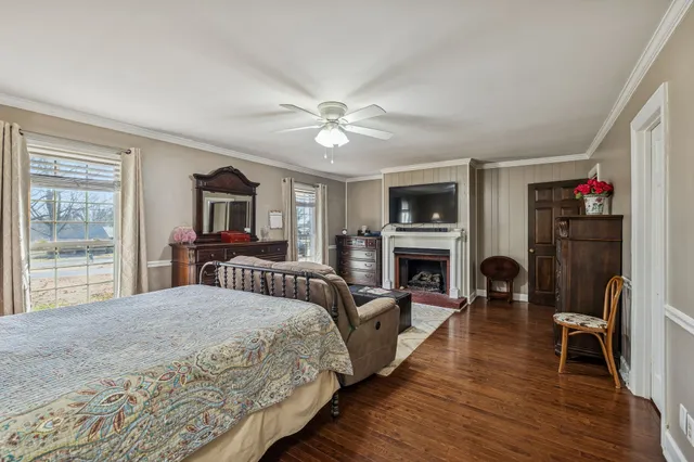 a bedroom with a bed a flat screen tv and a fireplace