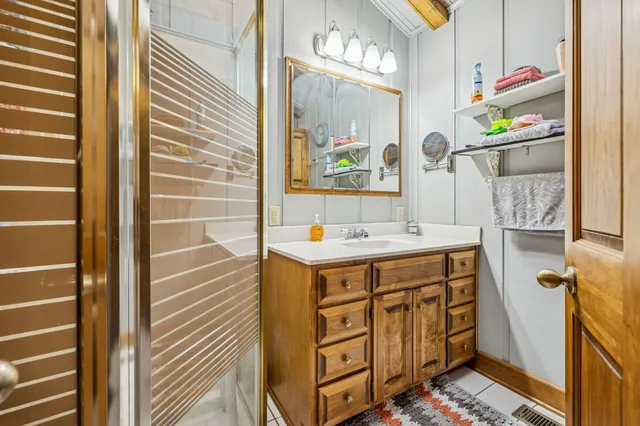 a bathroom with sink shower and mirror