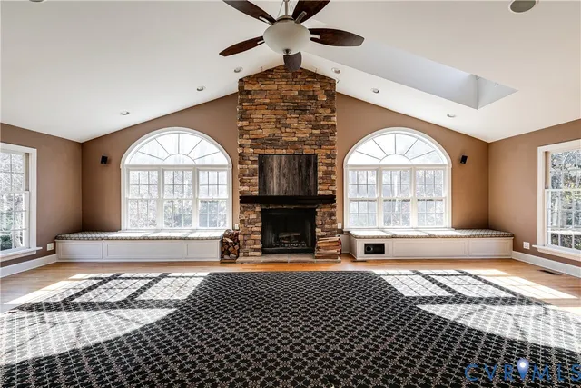 a view of an empty room with wooden floor and stairs