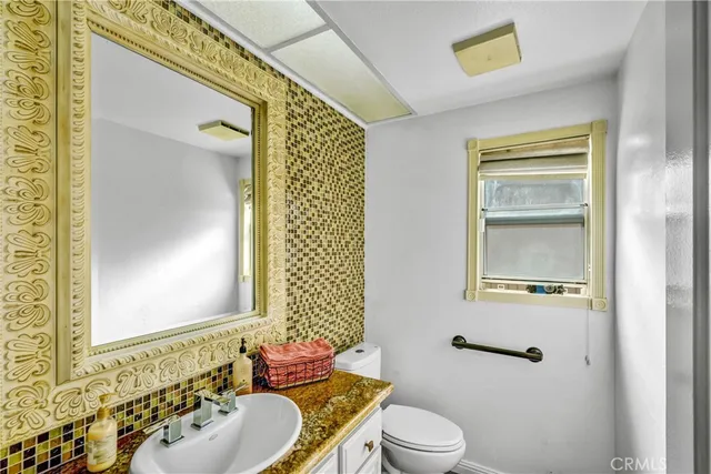 a bathroom with a sink and mirror with toilet