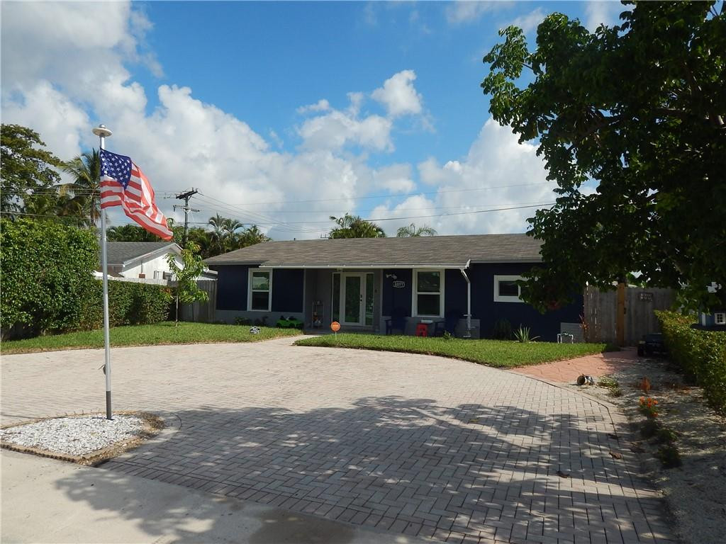 22277 Southwest 64th Avenue Boca Raton, FL 33428 - Photo 2 of 58 a front view of a house with a yard and trees