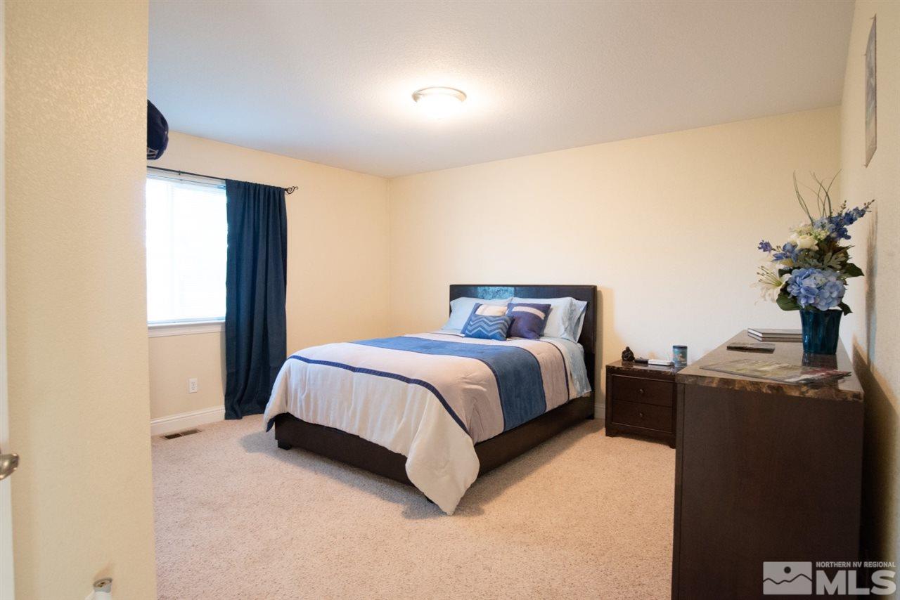4767 Rancheria Road Fallon, NV 89406 - Photo 13 of 25 a spacious bedroom with a bed and a potted plant
