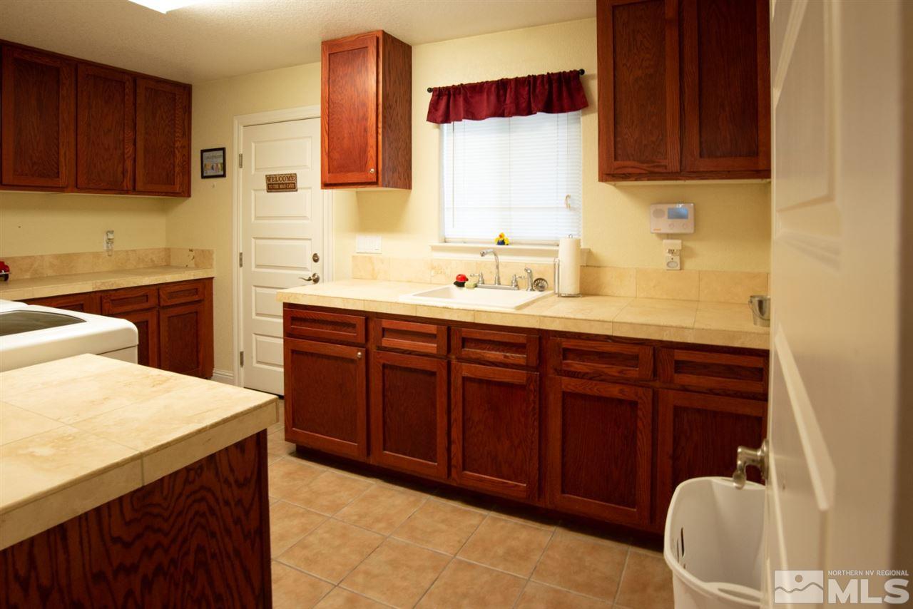 4767 Rancheria Road Fallon, NV 89406 - Photo 16 of 25 a kitchen with a sink and wooden cabinets